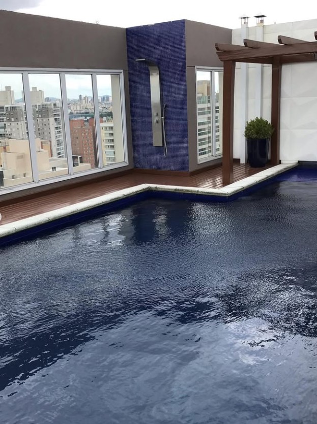 Piscina de cobertura com revestimento azul-escuro e vista da cidade