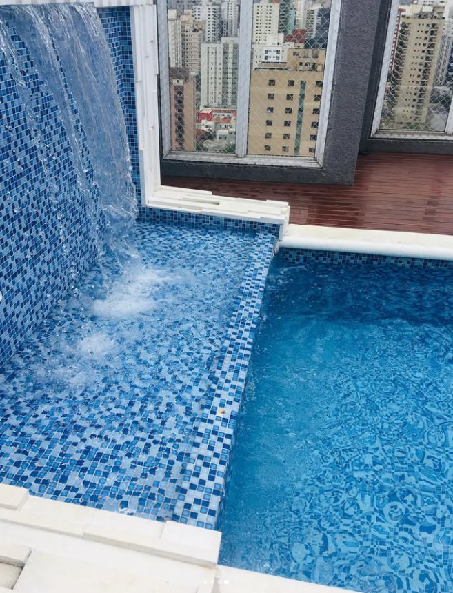 Piscina com cascata e revestimento em pastilhas azuis